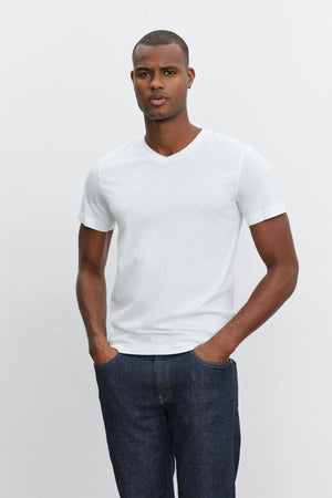 A man wearing a Velvet by Graham & Spencer SAMSEN WHISPER CLASSIC V-NECK TEE and jeans with a whisper knit fabric.