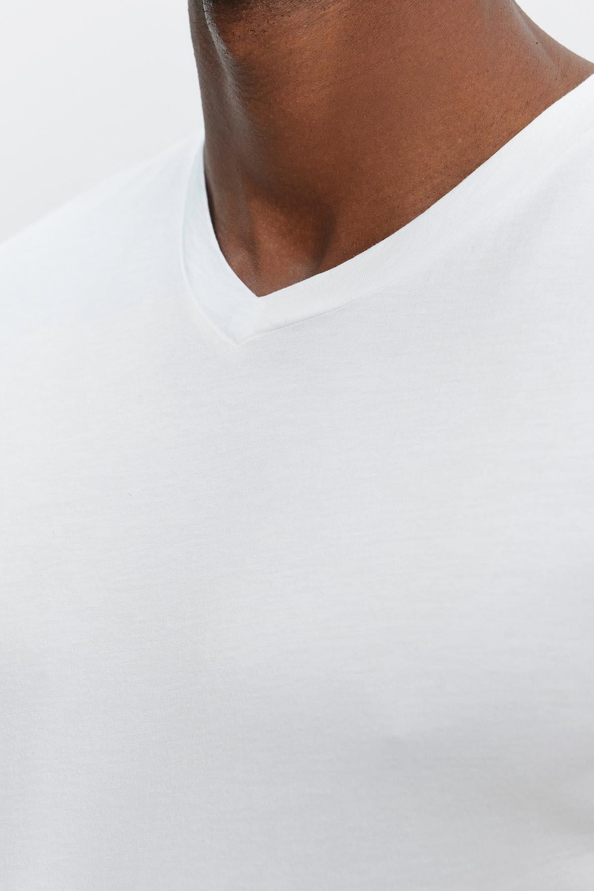 A close up of a man wearing a Velvet by Graham & Spencer SAMSEN WHISPER CLASSIC V-NECK TEE with a silhouette.-35867446083777