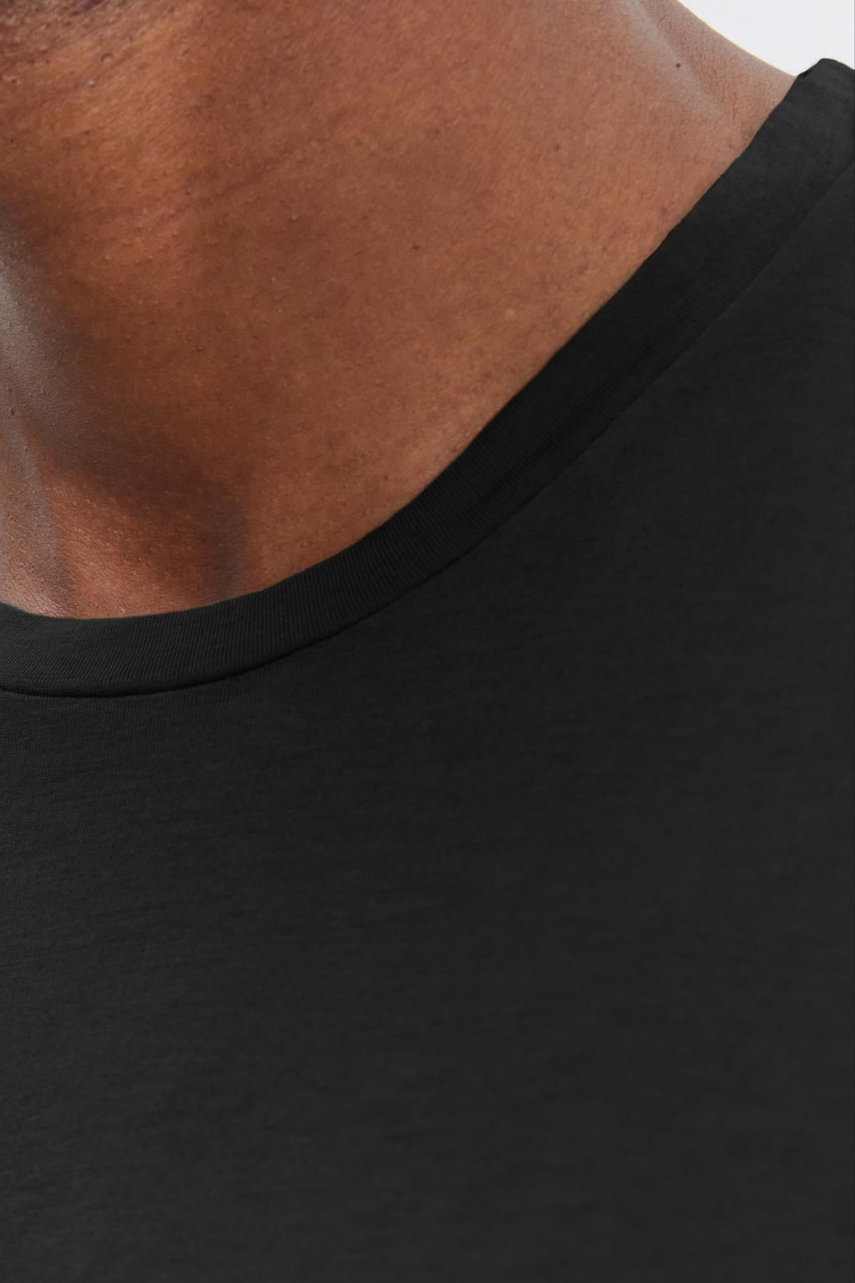   Close-up of a person wearing a Velvet by Graham & Spencer SKEETER WHISPER CLASSIC CREW NECK TEE, focusing on the neckline and part of the neck. 