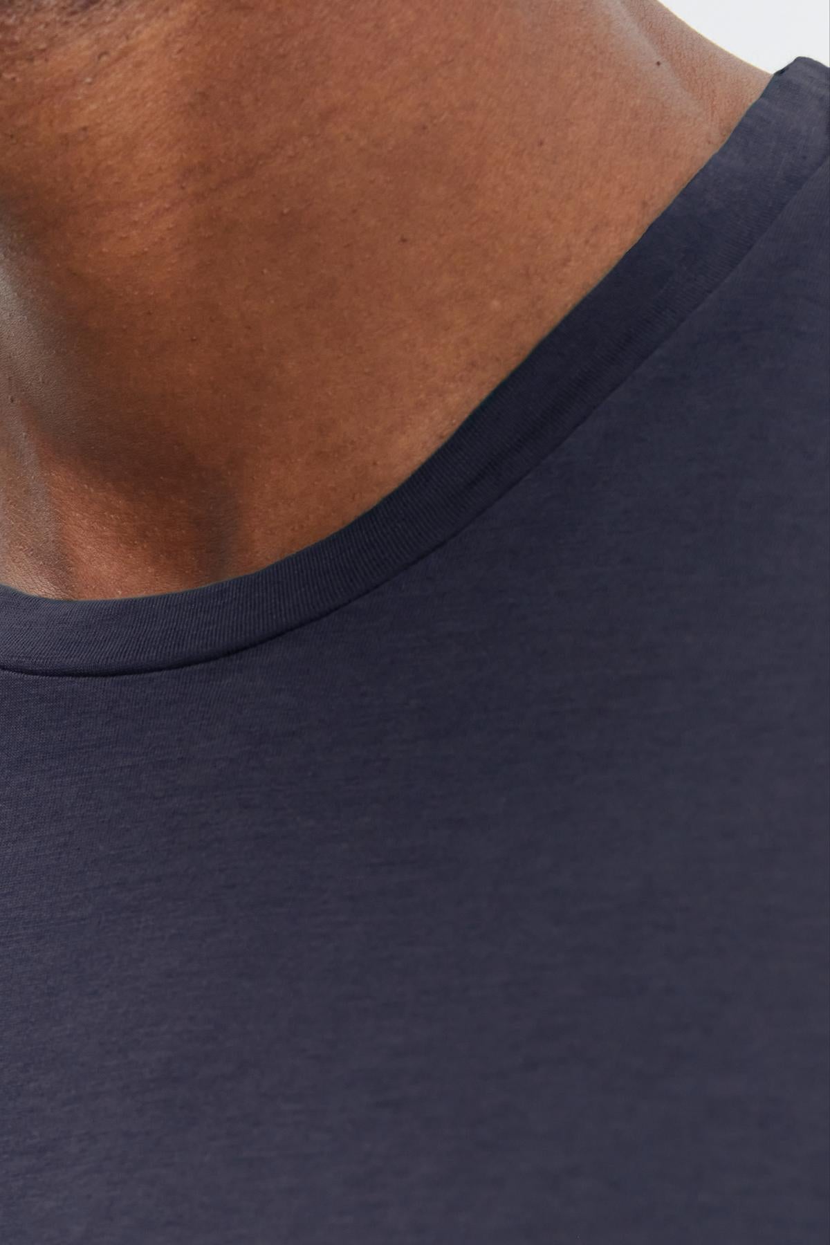 Close-up of a person wearing a Velvet by Graham & Spencer SKEETER WHISPER CLASSIC CREW NECK TEE, focusing on the collar area and part of the neck.-36342439411905