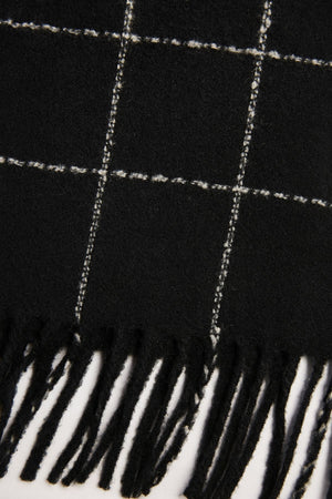 The WINDOWPANE MUFFLER by Velvet by Graham & Spencer features black fabric with white windowpane checks and fringed edges.
