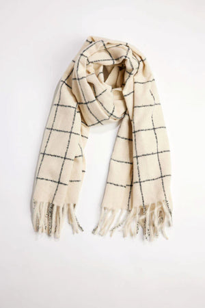 The WINDOWPANE MUFFLER by Velvet by Graham & Spencer is a cream scarf featuring a black windowpane check and fringed ends, shown laid flat on a white background.