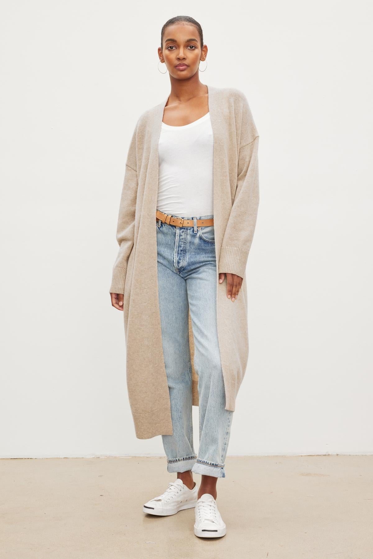 A model wearing jeans and the Velvet by Graham & Spencer LISA WOOL CASHMERE DUSTER CARDIGAN in beige.-26921634660545