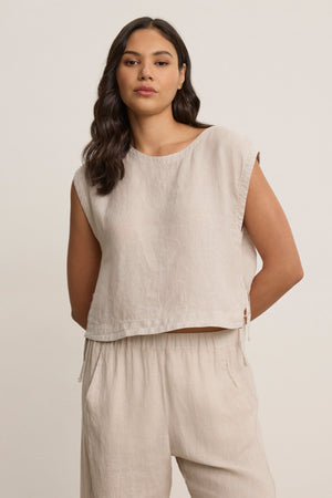 A woman models the TAVIA LINEN TOP by Velvet by Graham & Spencer, a sleeveless, breathable linen piece paired with matching wide-leg pants, standing against a plain light background.