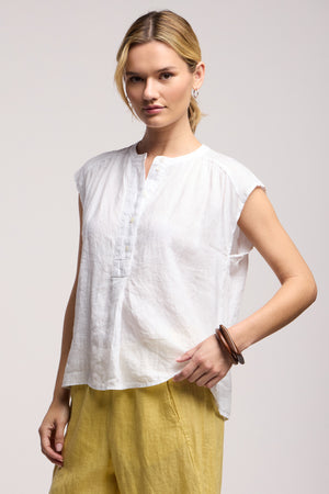 A person wearing the BEC LINEN TOP by Velvet by Graham & Spencer and yellow pants stands facing the camera against a plain background.