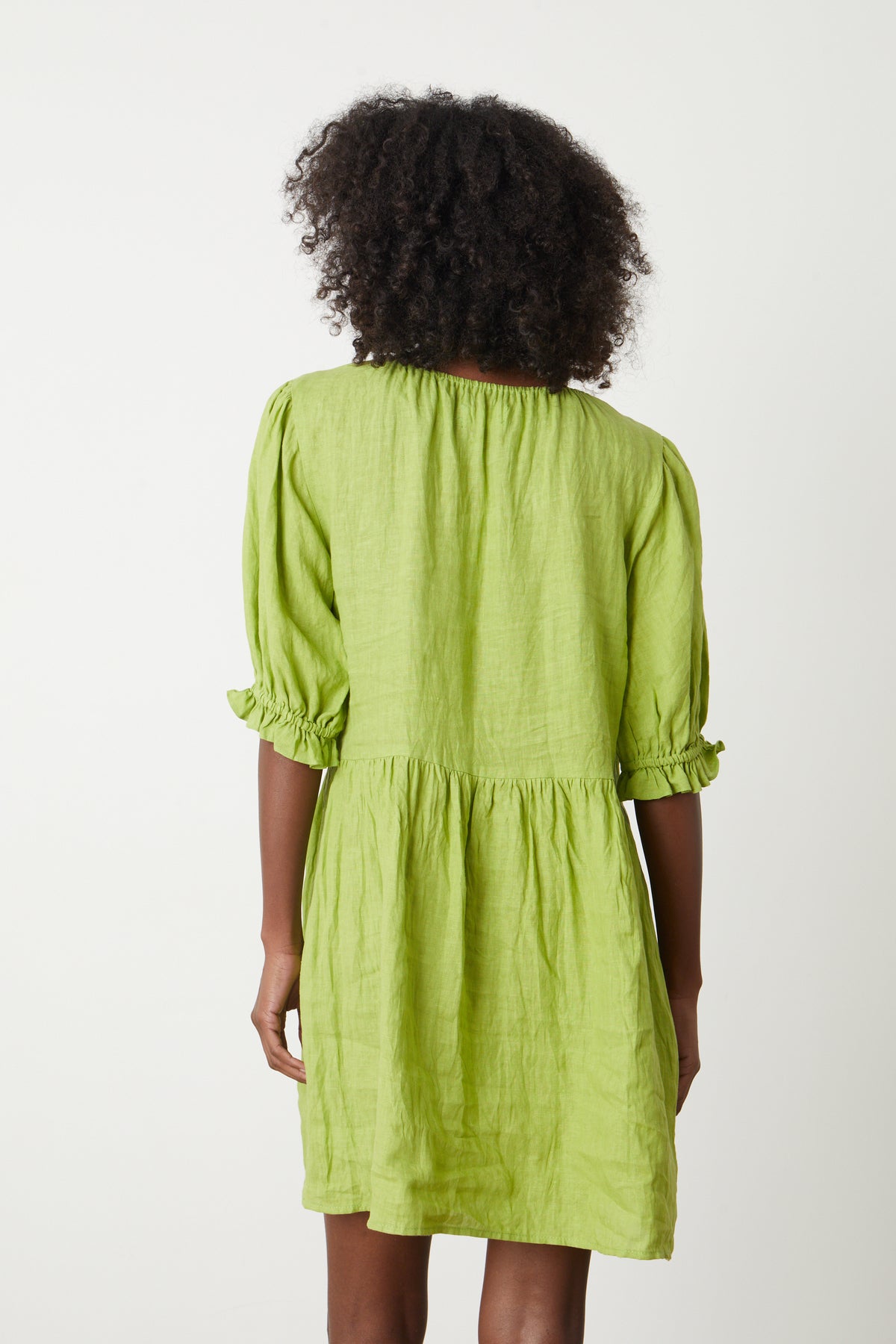 The back view of a woman wearing a Velvet by Graham & Spencer KAILANI LINEN PUFF SLEEVE DRESS.-35204898095297
