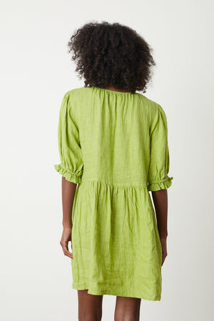 The back view of a woman wearing a Velvet by Graham & Spencer KAILANI LINEN PUFF SLEEVE DRESS.