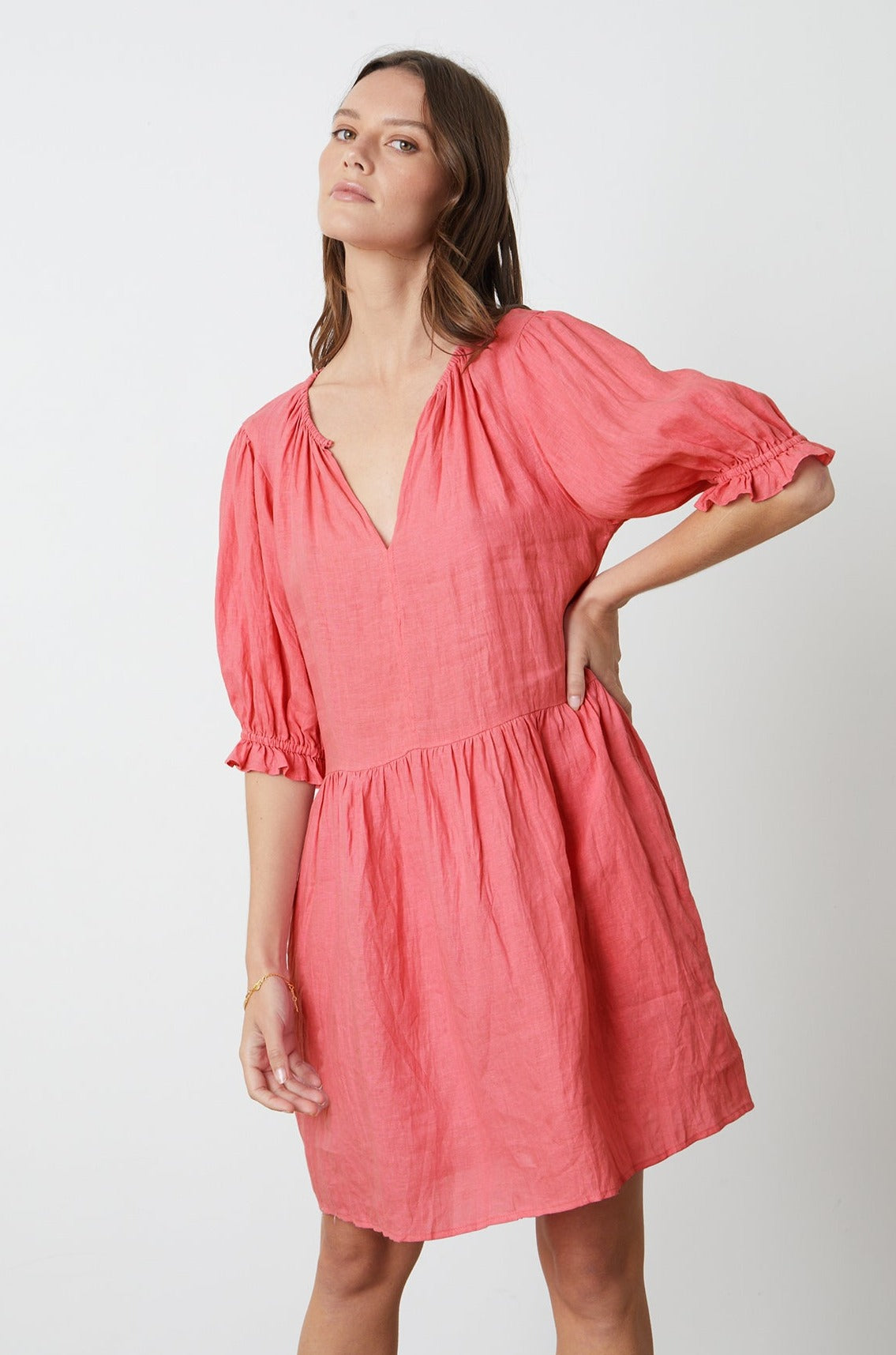 The model is wearing a Velvet by Graham & Spencer KAILANI LINEN PUFF SLEEVE DRESS with ruffled sleeves.-26342704382145