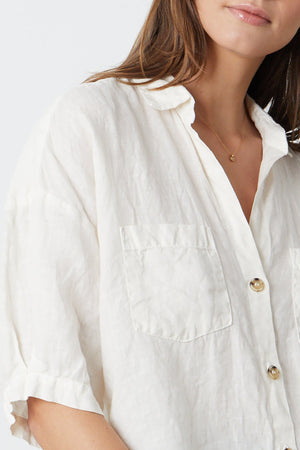 the model is wearing a white MARIA LINEN BUTTON-UP SHIRT.