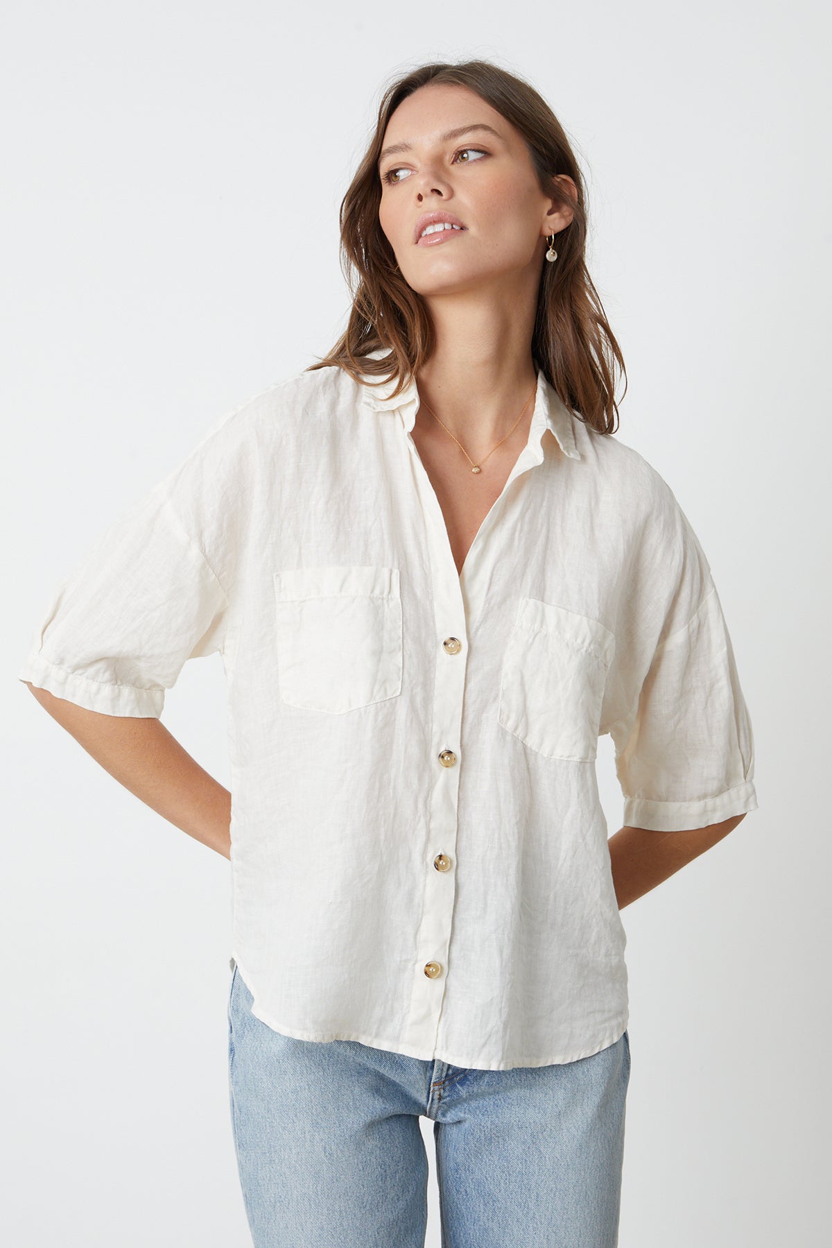 a model wearing a white MARIA LINEN BUTTON-UP SHIRT by Velvet by Graham & Spencer and jeans.-26715366981825