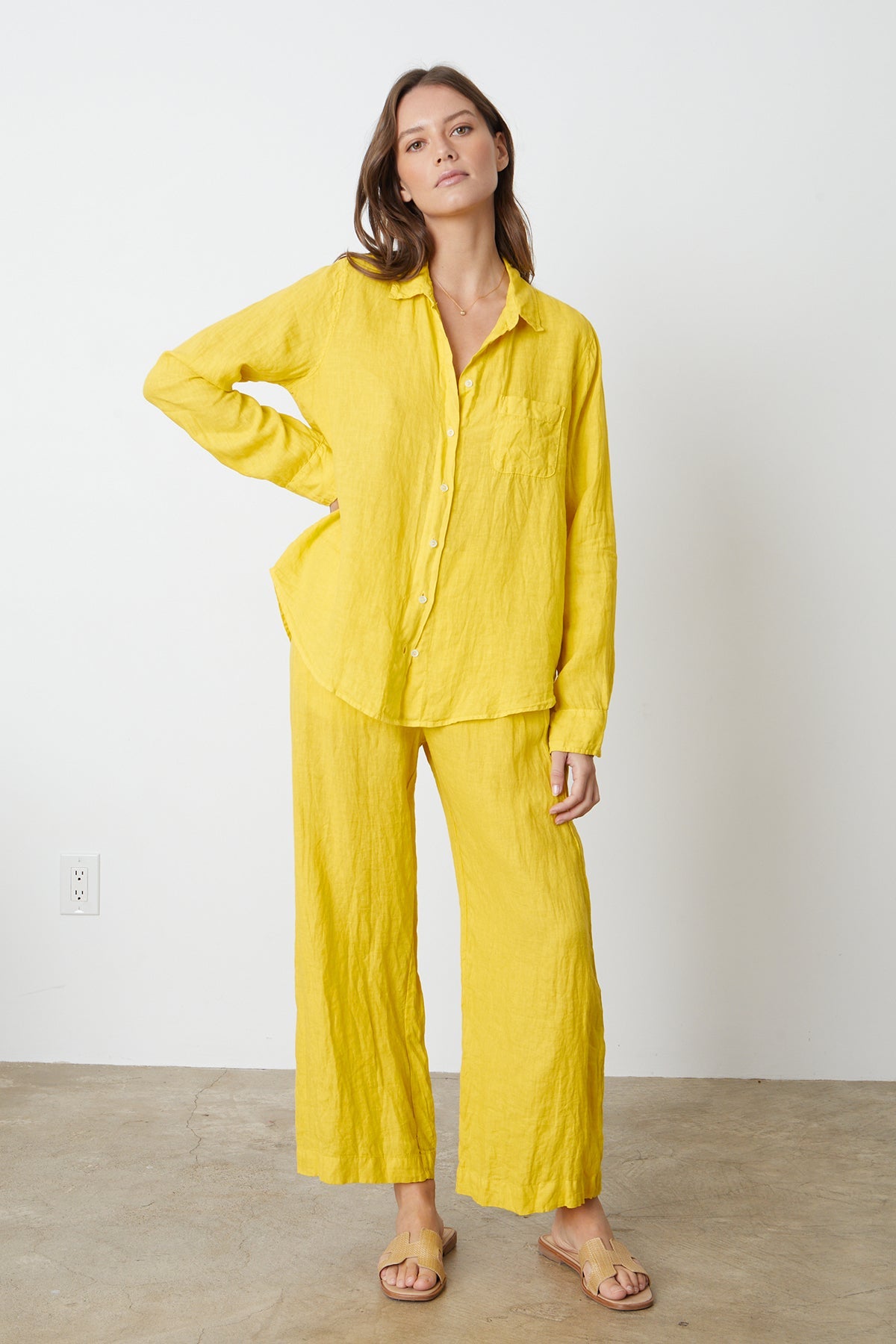   Woman standing with hand on hip wearing Natalia Button-Up Shirt in bright yellow sun colored linen with Lola pant full length front 