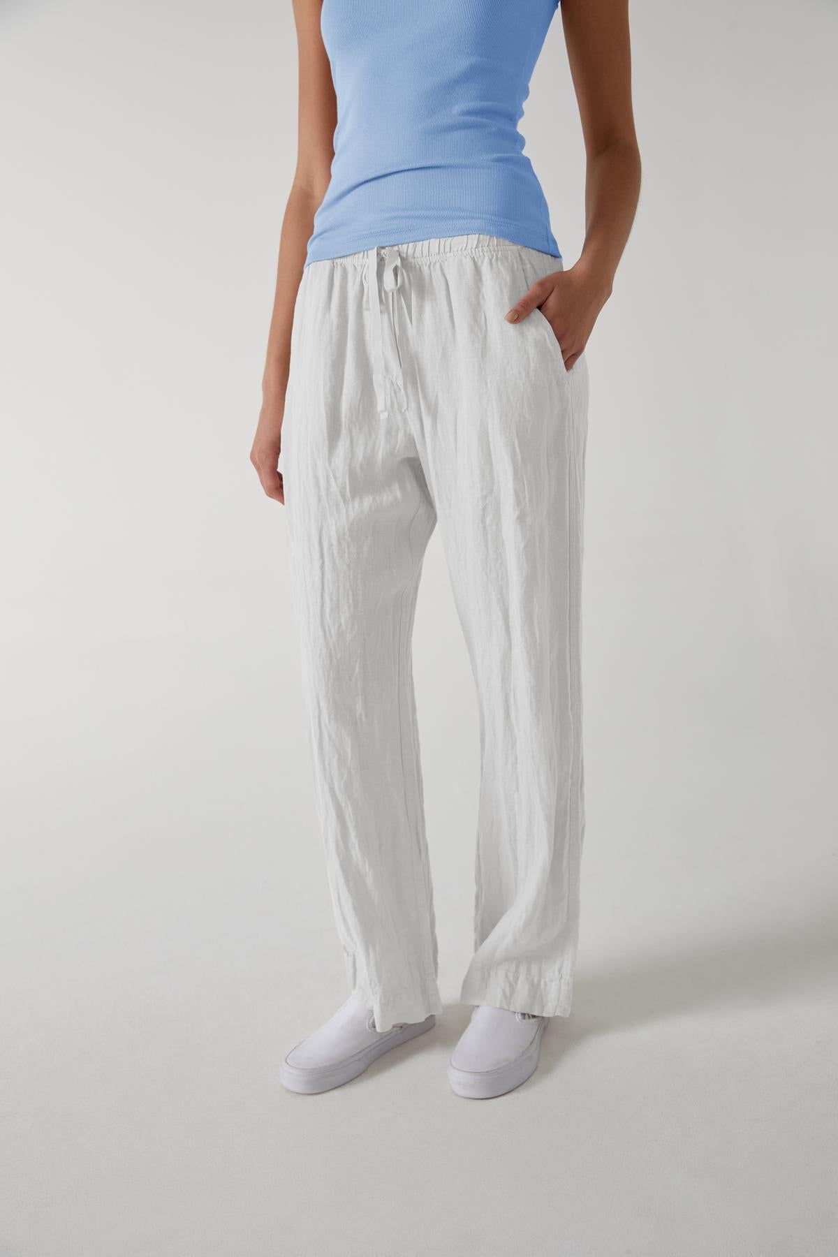 A woman wearing white linen PICO pants by Velvet by Jenny Graham and a relaxed fit blue top.-36168897691841
