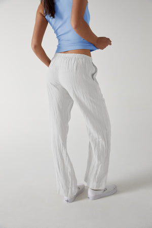 A woman wearing white Velvet by Jenny Graham PICO pants and a blue top.