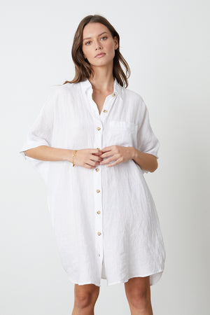 A model wearing a white STEVIE LINEN BUTTON-UP DRESS by Velvet by Graham & Spencer.