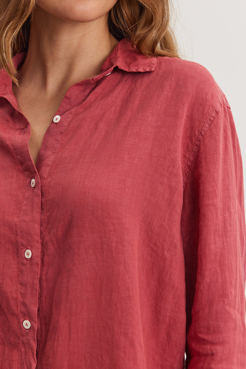 Close-up of a woman wearing a red woven linen WILLOW LINEN BUTTON-UP SHIRT by Velvet by Graham & Spencer with a focus on the collar and button details.