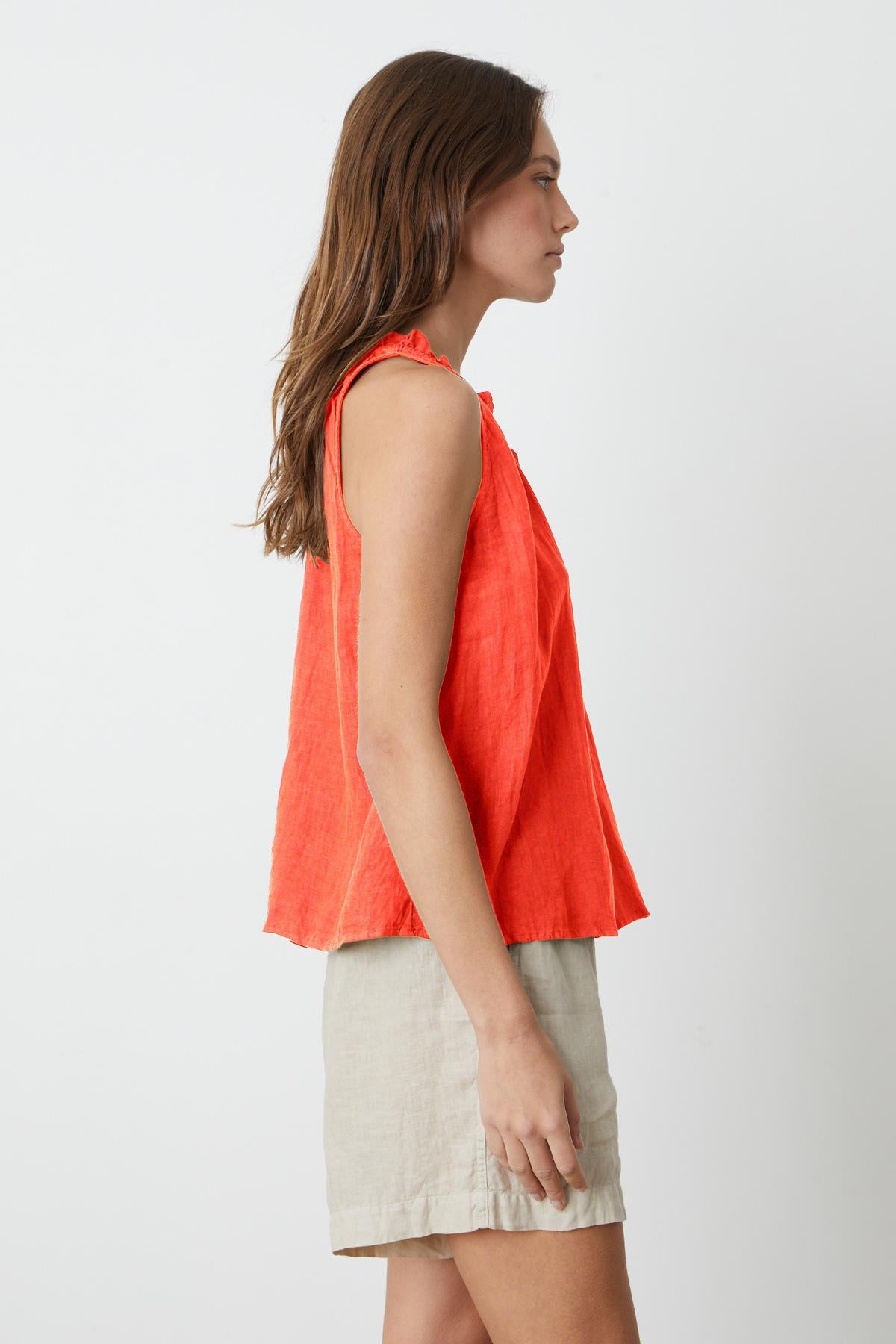   The back view of a woman wearing a ZOEY LINEN V-NECK TANK TOP by Velvet by Graham & Spencer and tan shorts. 