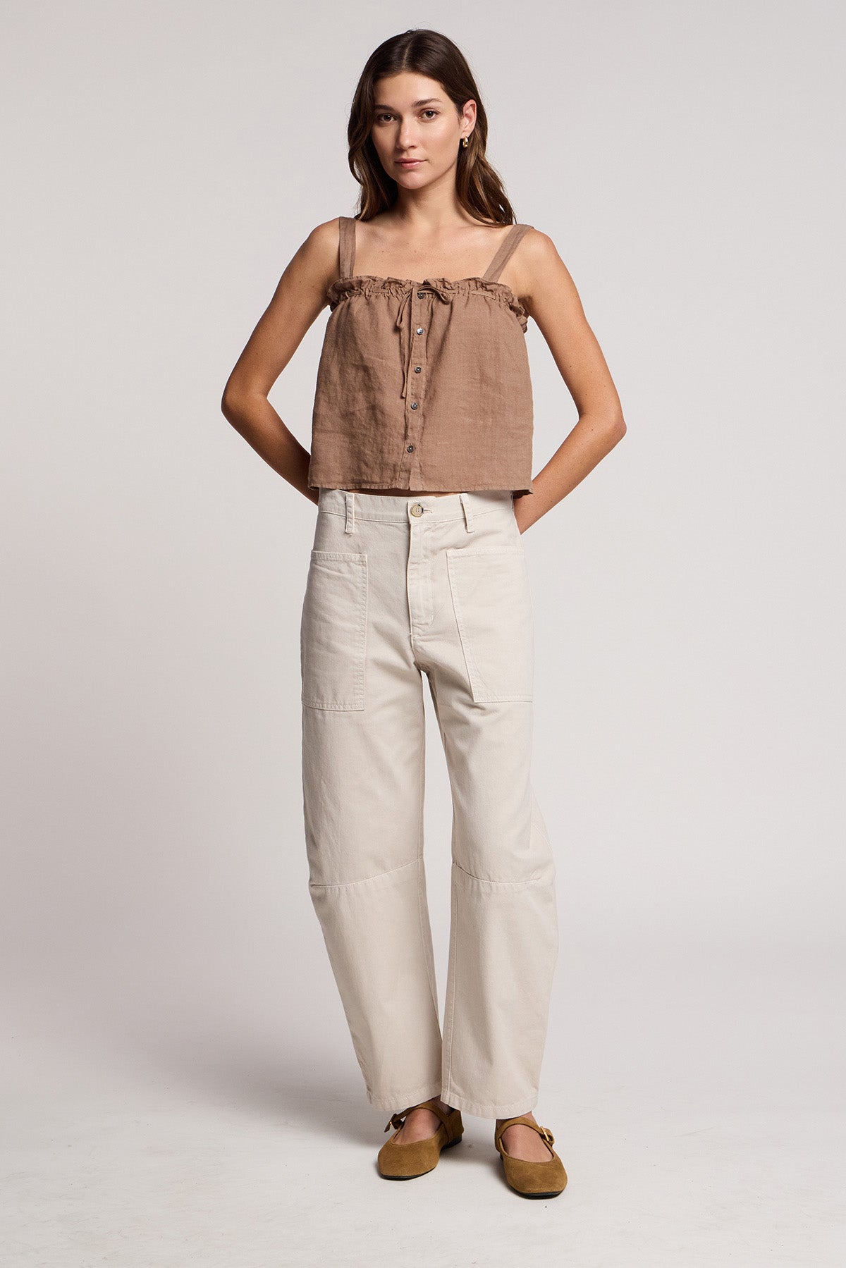 A woman stands against a plain background wearing the IZZIE LINEN TANK TOP by Velvet by Graham & Spencer, styled with light high-waisted pants and brown flat shoes.-41527050305729