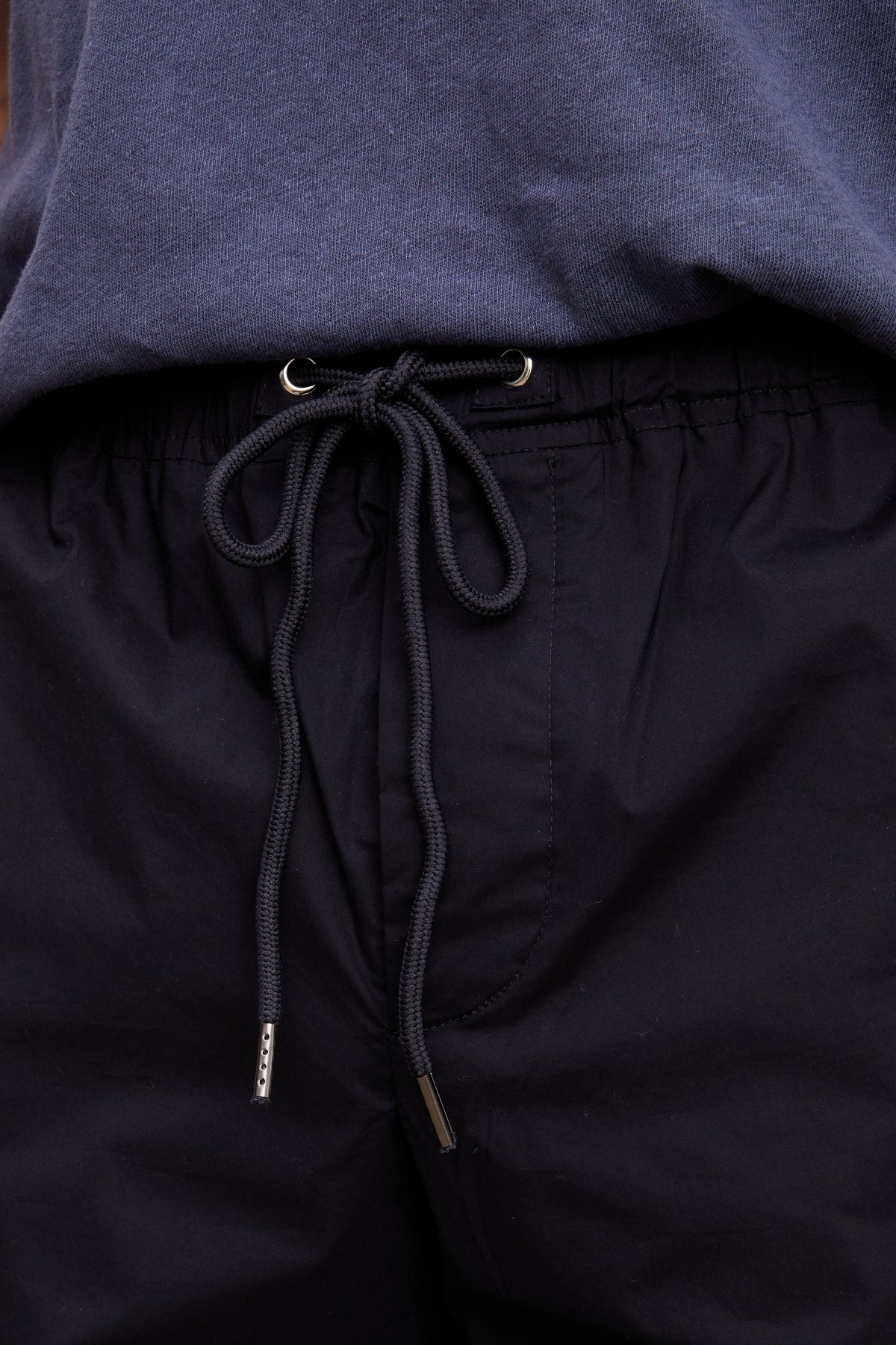 Close-up of a black drawstring with metal aglets on Velvet by Graham & Spencer's LAZARUS JOGGER under a blue sweatshirt.-36732528918721