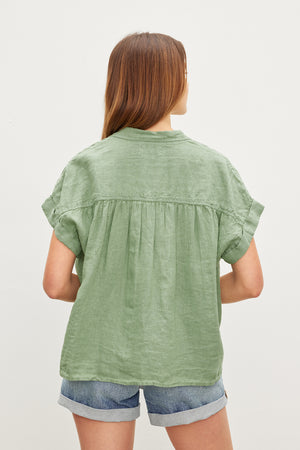 The back view of a woman wearing a Velvet by Graham & Spencer ARIA LINEN BUTTON FRONT TOP exudes comfort.