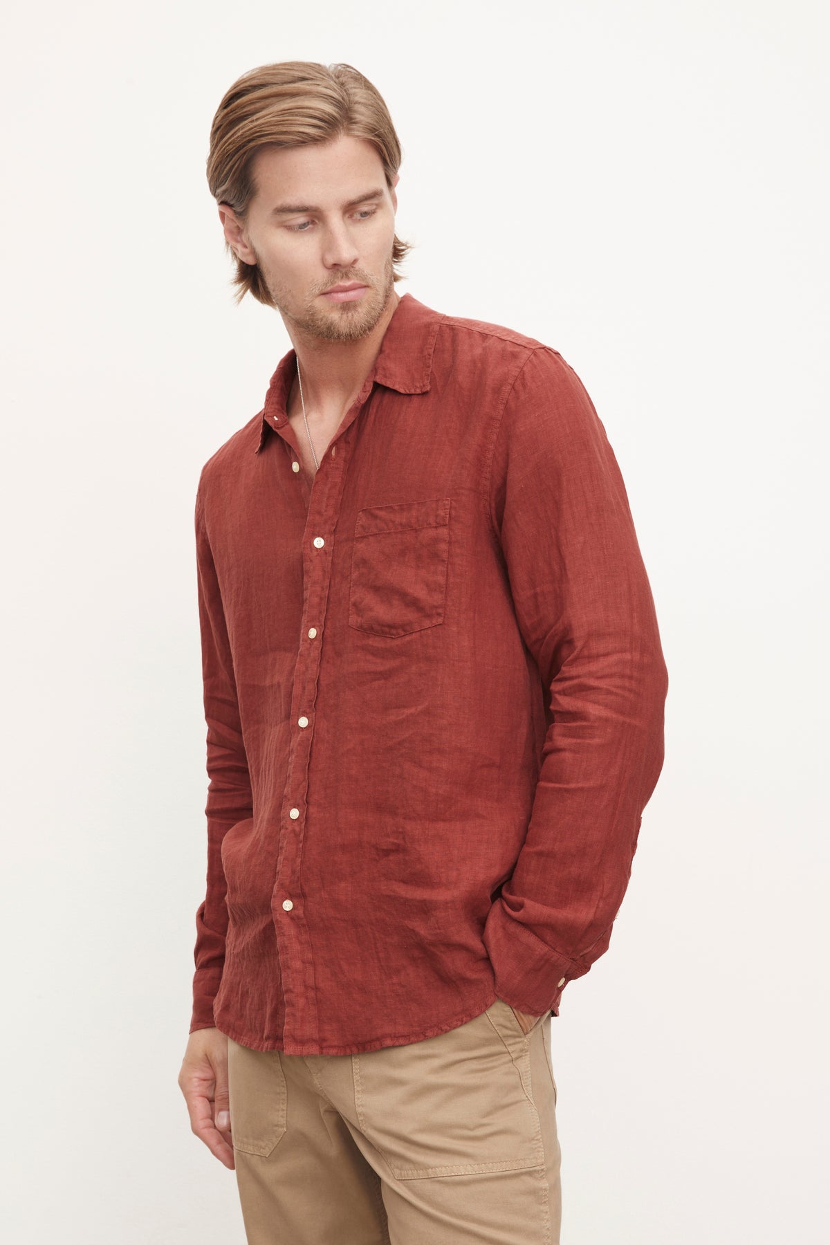   A stylish man wearing a Benton Linen Button-Up Shirt by Velvet by Graham & Spencer in red. 