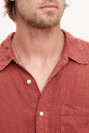 A stylish man in a Velvet by Graham & Spencer BENTON LINEN BUTTON-UP SHIRT with a necklace.