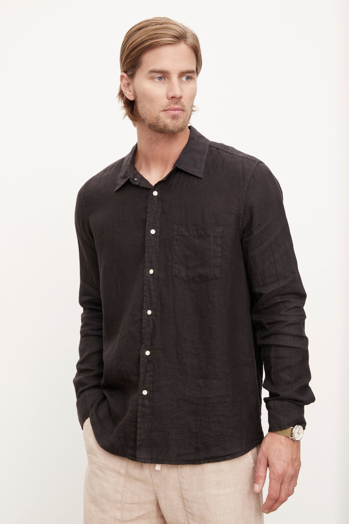 A stylish man wearing a Velvet by Graham & Spencer men's Benton linen button-up shirt with khaki pants.-36009360457921