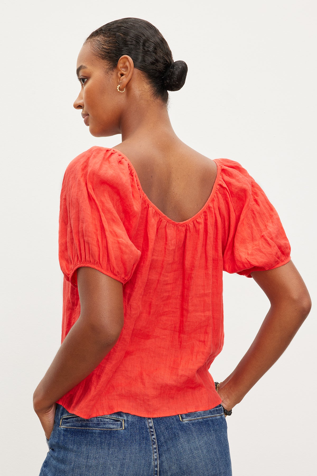   The back view of a woman wearing a Velvet by Graham & Spencer DANA LINEN SCOOP NECK TOP and jeans. 