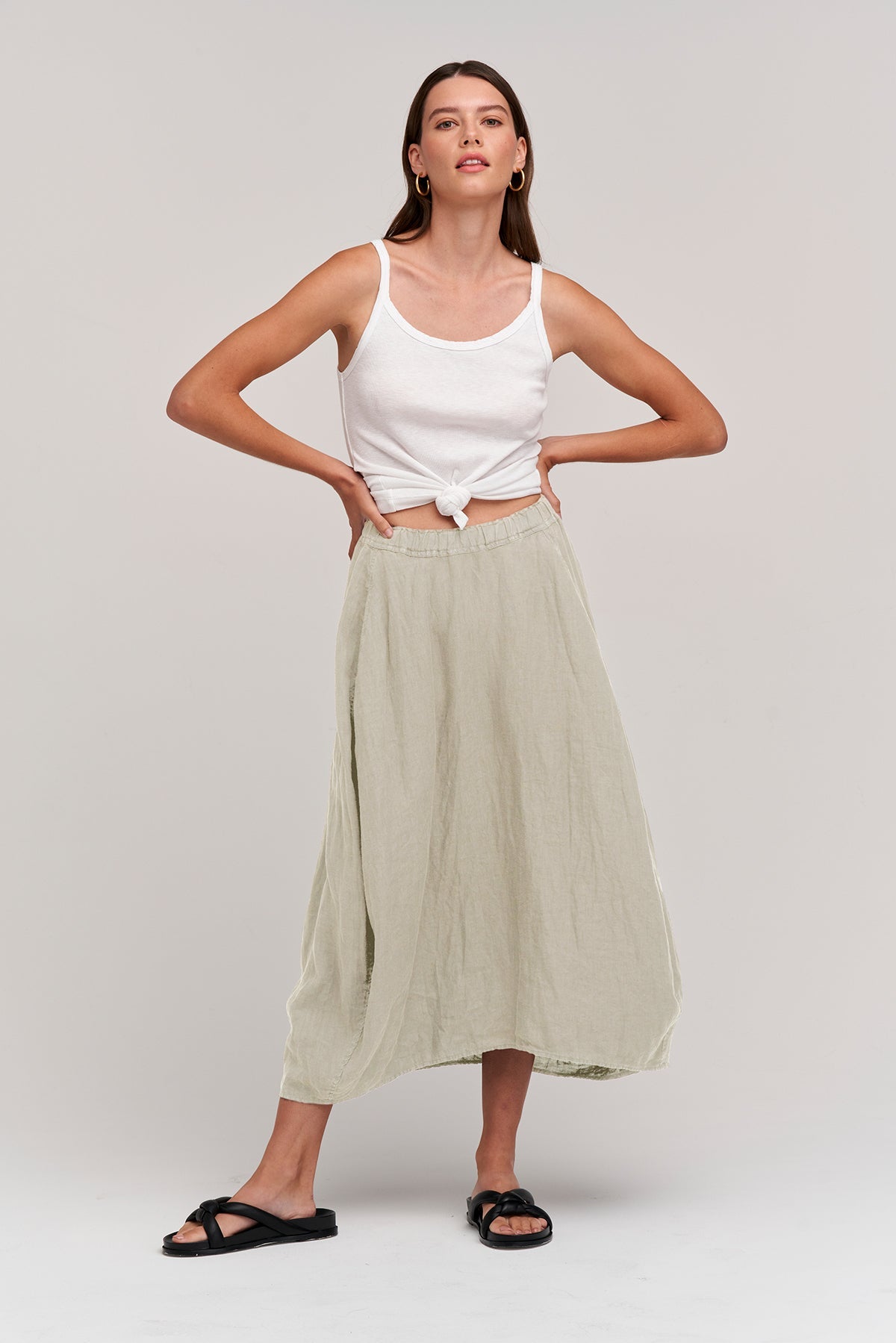   The model is wearing a white tank top and a Velvet by Graham & Spencer FAE LINEN A-LINE SKIRT. 