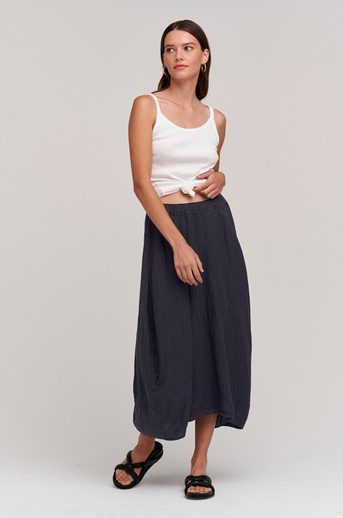   a model wearing a FAE LINEN A-LINE SKIRT by Velvet by Graham & Spencer and white tank top. 