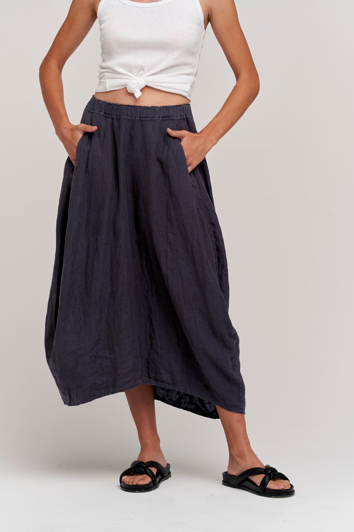 The model is wearing a Velvet by Graham & Spencer FAE LINEN A-LINE SKIRT with pockets.-35954052006081