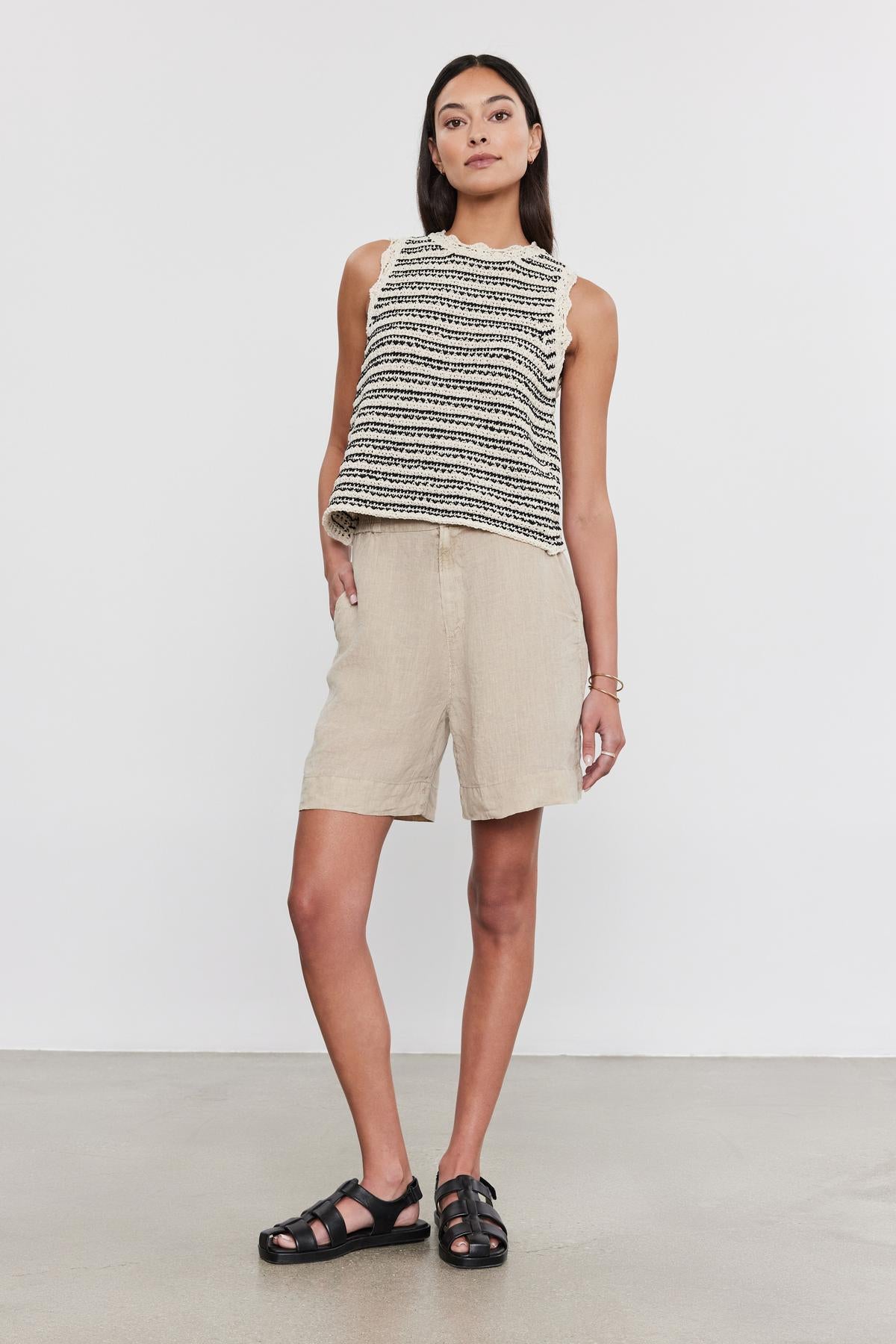 A woman in a sleeveless knit top and FRANCIS LINEN SHORT by Velvet by Graham & Spencer standing against a neutral background, wearing black sandals.-36910046675137