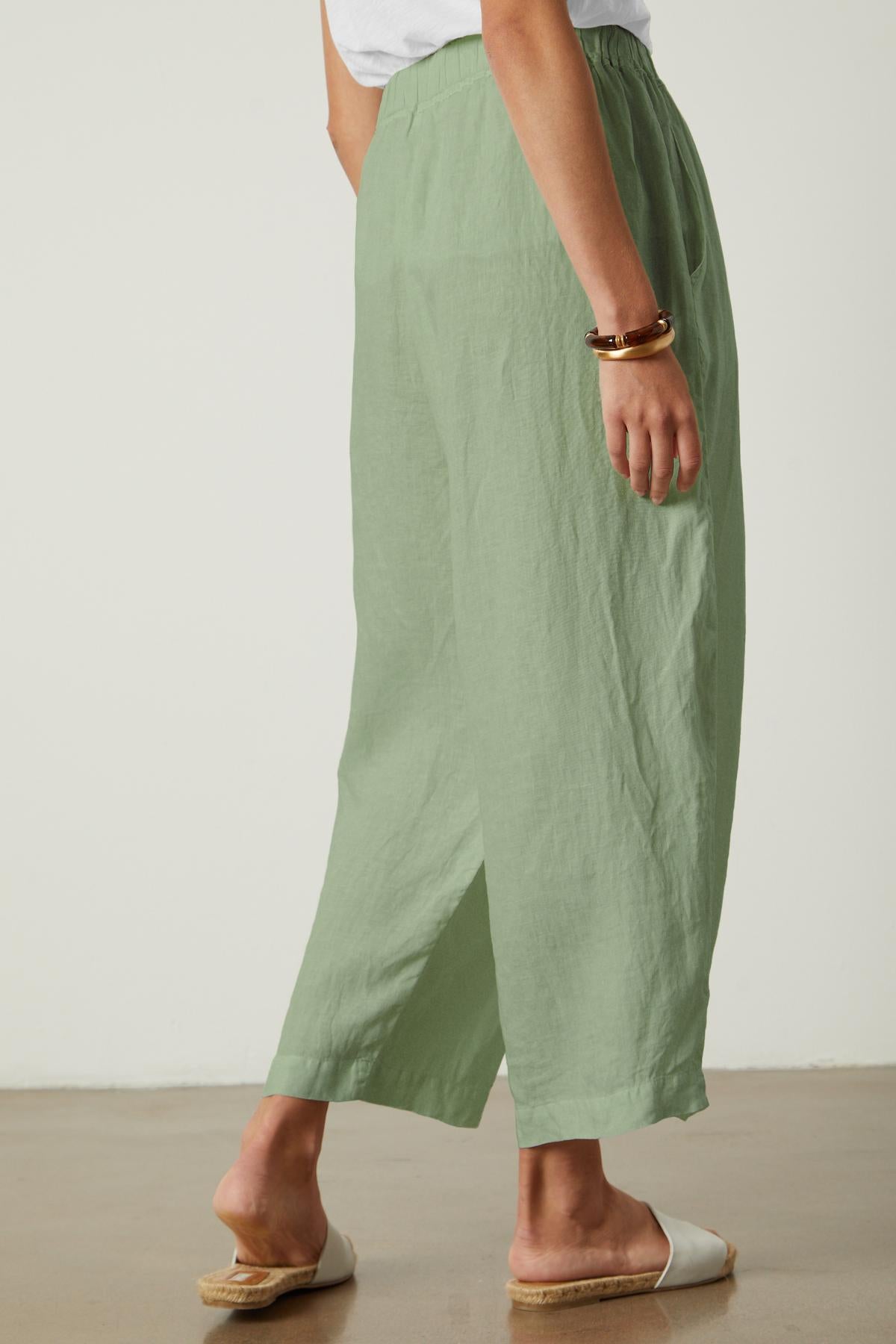 The back view of a woman wearing Velvet by Graham & Spencer's HANNAH LINEN WIDE LEG PANT with cropped legs.-35982790164673