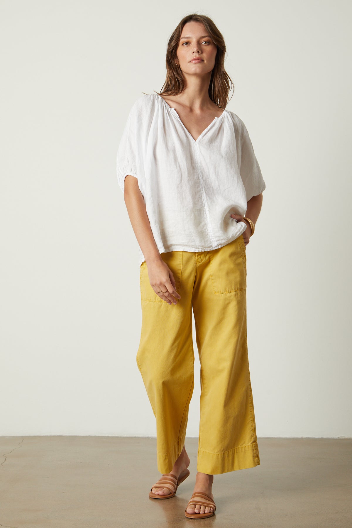 The model is wearing a Velvet by Graham & Spencer JANINE LINEN TOP and yellow wide leg pants.-26445315539137