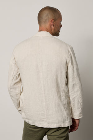 The back view of a man wearing a Velvet by Graham & Spencer JOSHUA LINEN BLAZER.