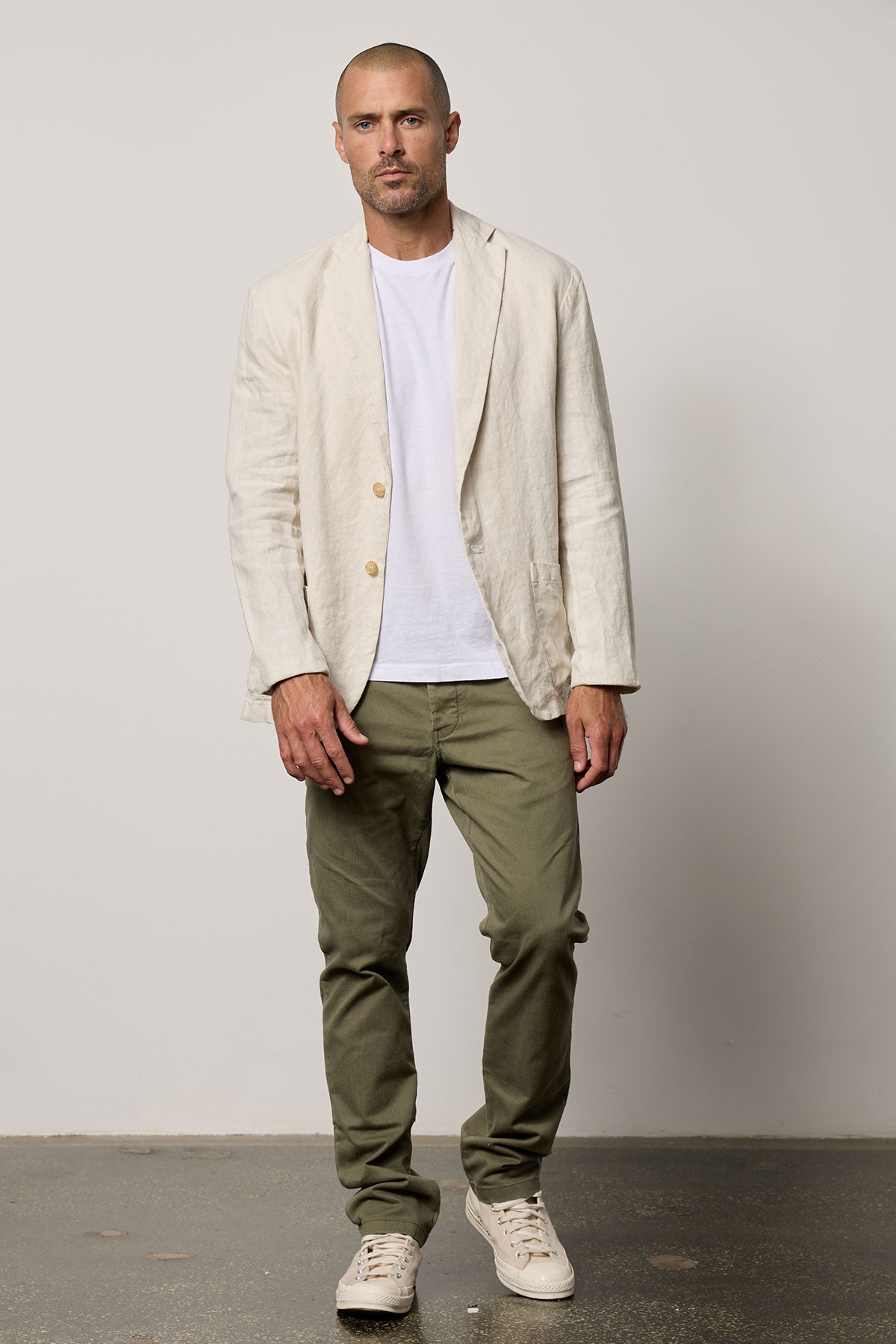 A man in a tailored fit JOSHUA LINEN BLAZER by Velvet by Graham & Spencer and green pants.-35678528176321