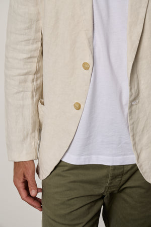 a man wearing a JOSHUA LINEN BLAZER by Velvet by Graham & Spencer and green pants.