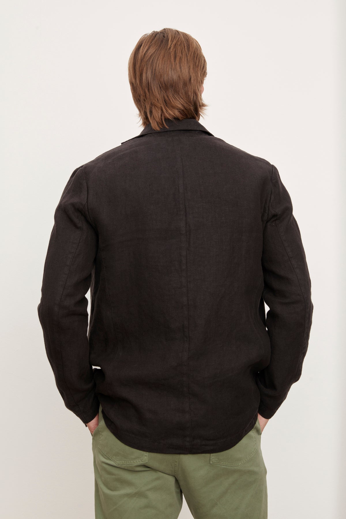   The back of a man wearing a Velvet by Graham & Spencer JOSHUA LINEN BLAZER and green pants. 