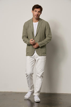a man wearing a Velvet by Graham & Spencer JOSHUA LINEN BLAZER and white pants.