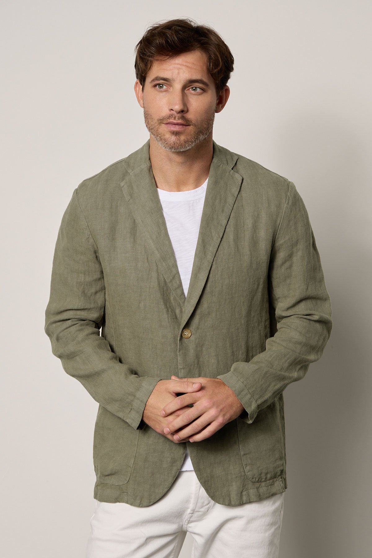   A man wearing a Velvet by Graham & Spencer JOSHUA LINEN BLAZER adorned in a green linen jacket. 