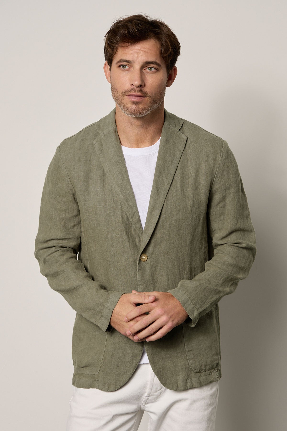 A man wearing a Velvet by Graham & Spencer JOSHUA LINEN BLAZER adorned in a green linen jacket.-35678532075713