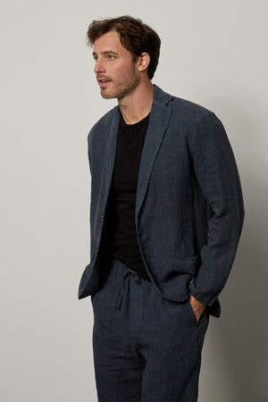 A man wearing a Joshua Linen Blazer by Velvet by Graham & Spencer and a black t-shirt.