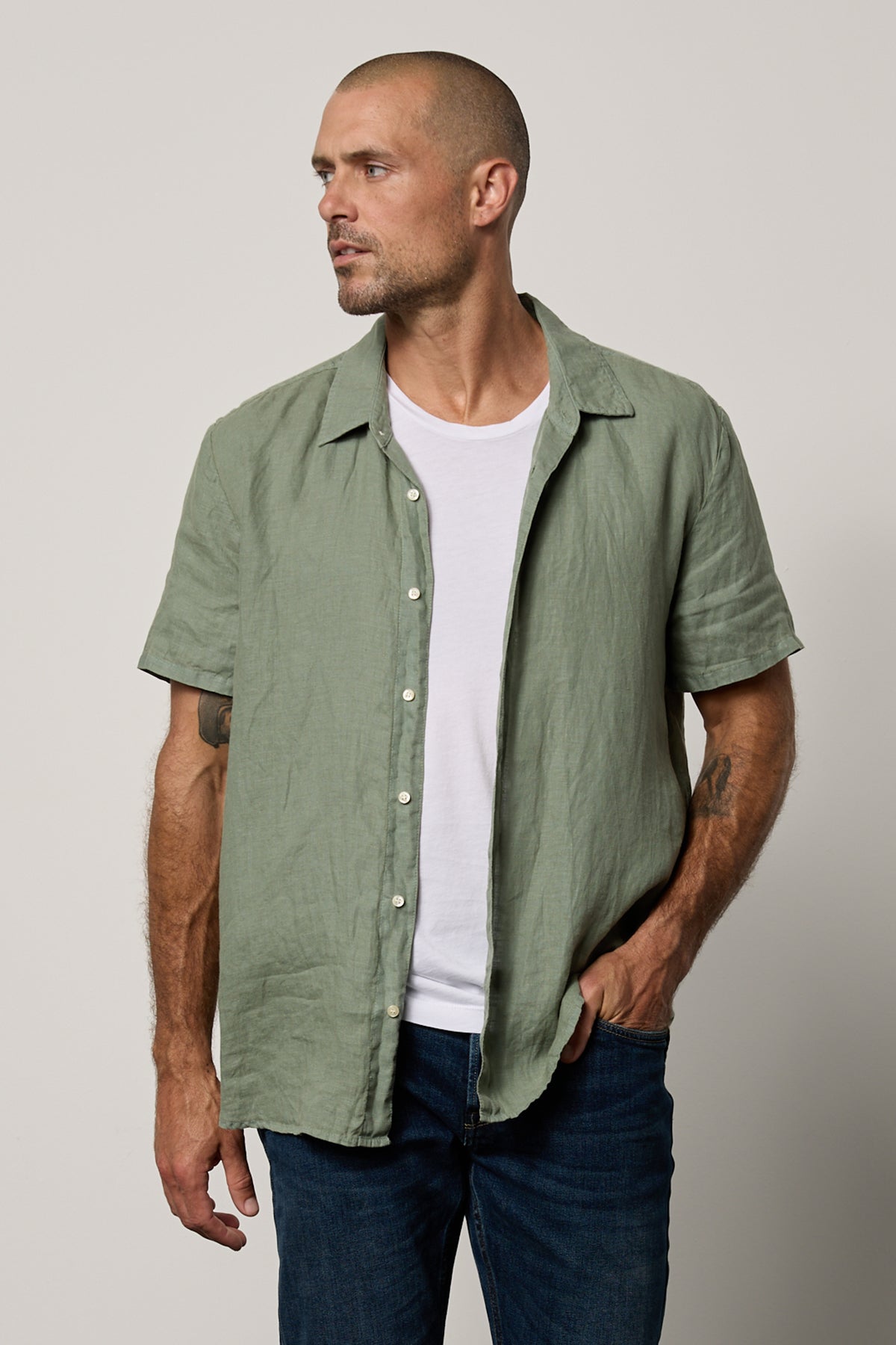   Mackie Button-Up Shirt in cactus soft green unbuttoned over white Howard Tee with dark blue denim front 