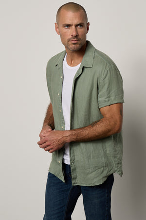 Mackie Button-Up Shirt in cactus soft green unbuttoned over white Howard Tee with dark blue denim front & side