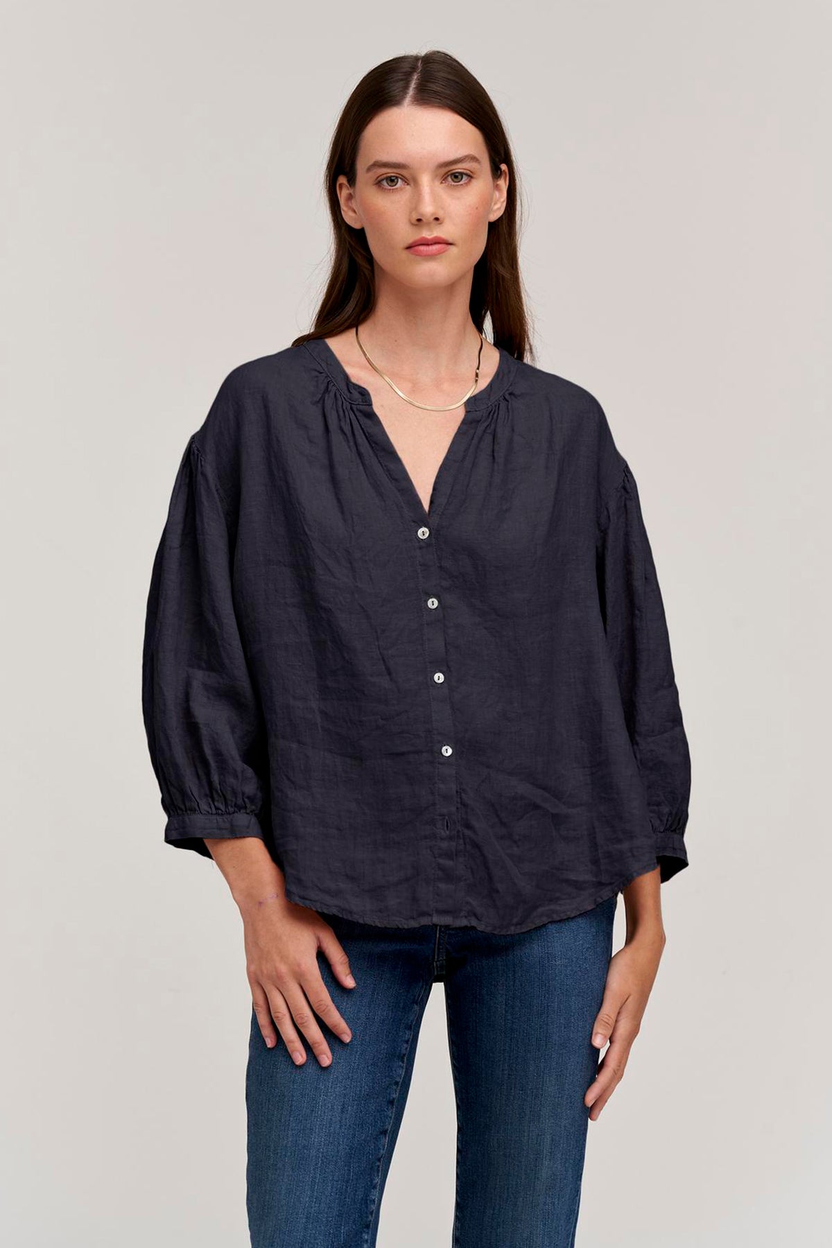 a model wearing jeans and a MATEA LINEN BUTTON-UP BLOUSE by Velvet by Graham & Spencer.-26312381694145