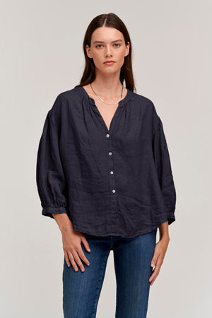 a model wearing jeans and a MATEA LINEN BUTTON-UP BLOUSE by Velvet by Graham & Spencer.