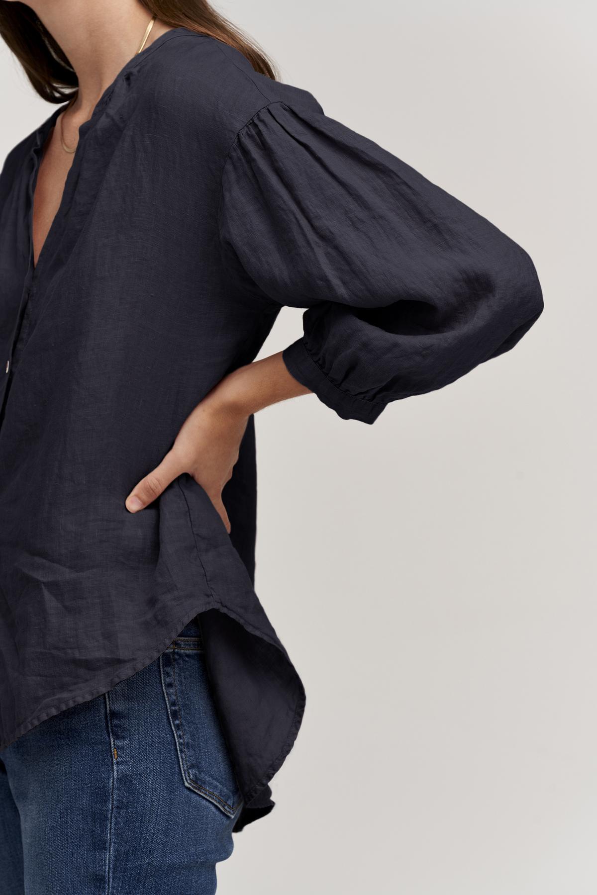   The model is wearing jeans and a Velvet by Graham & Spencer MATEA LINEN BUTTON-UP BLOUSE. 