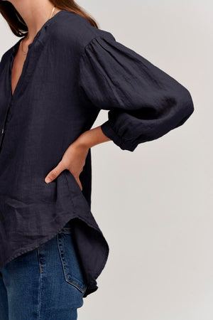 The model is wearing jeans and a Velvet by Graham & Spencer MATEA LINEN BUTTON-UP BLOUSE.