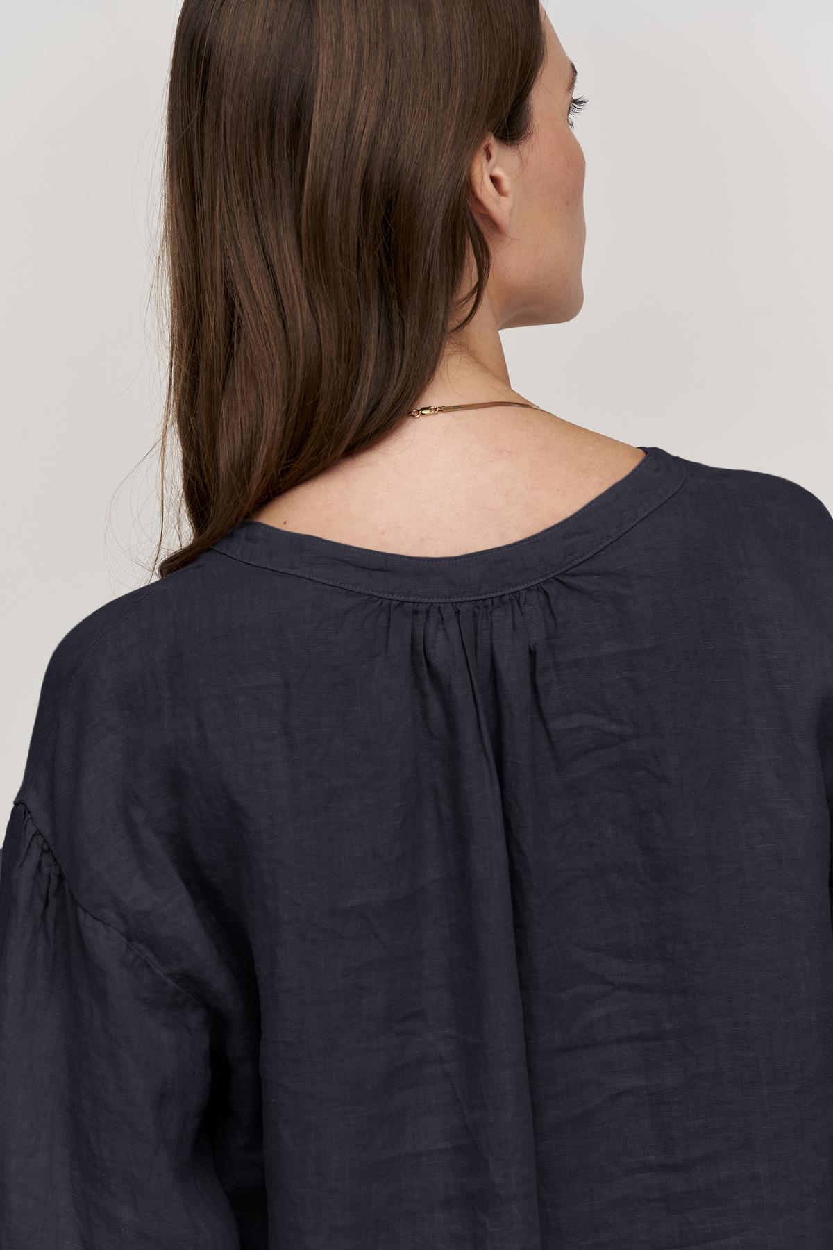 the back view of a woman wearing a Velvet by Graham & Spencer MATEA LINEN BUTTON-UP BLOUSE.-26312381792449
