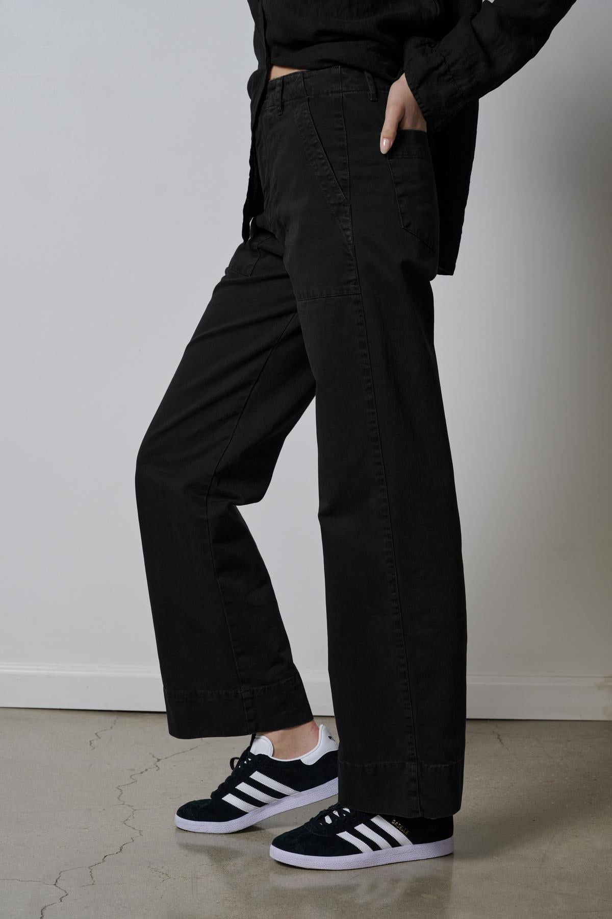   A woman wearing Velvet by Jenny Graham's black wide leg VENTURA PANT and sneakers. 