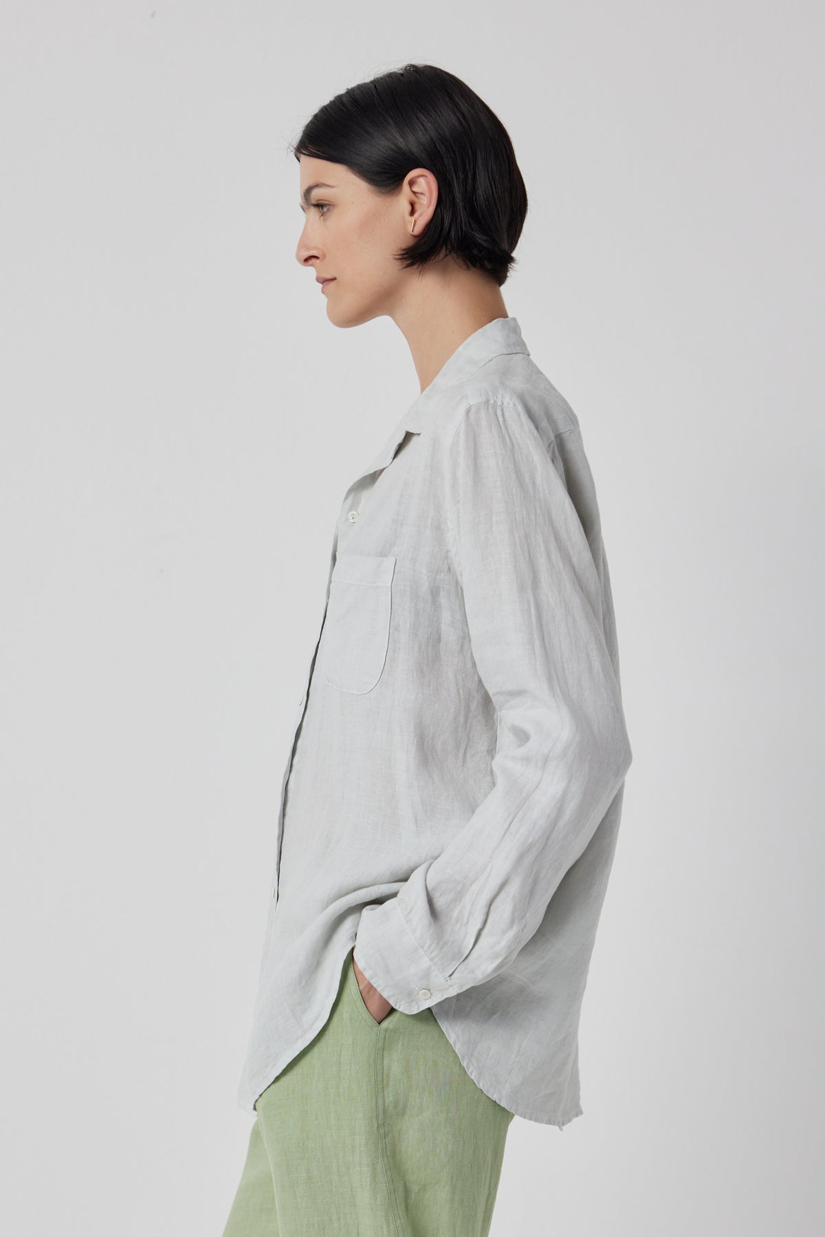 The model is wearing a grey Velvet by Jenny Graham linen button up shirt and green pants.-36212529725633